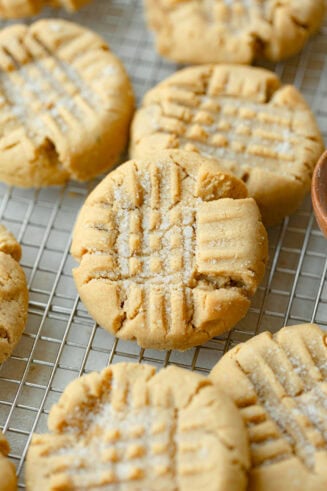 a photo of several classic peanut butter cookies sitting on a wire cooling rack