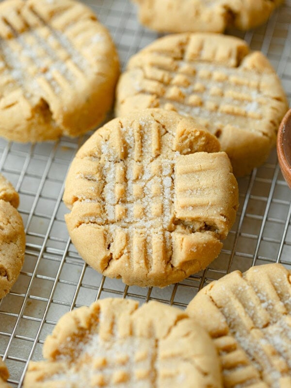 a photo of several classic peanut butter cookies sitting on a wire cooling rack