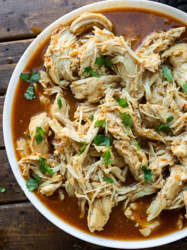 a photo of shredded seasoned chicken in a white serving bowl