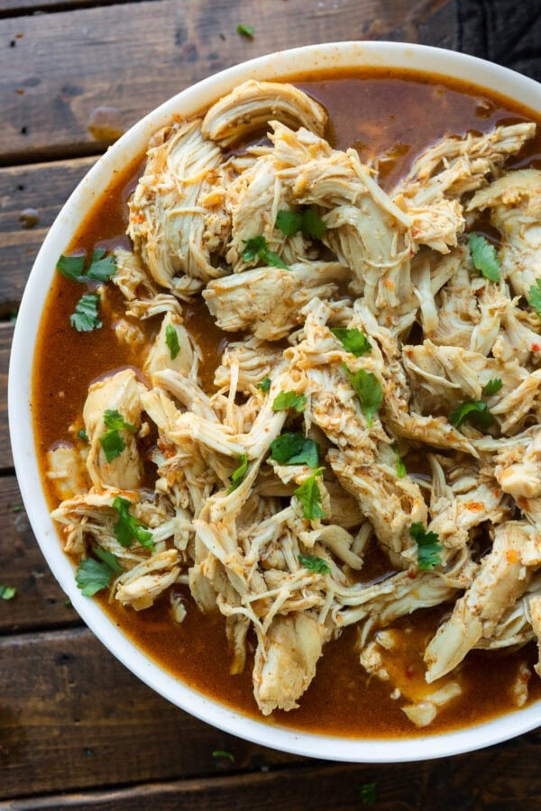 a photo of shredded seasoned chicken in a white serving bowl