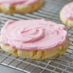 A photo of a copycat Swig sugar cookie with pink frosting sitting on a cooling rack.