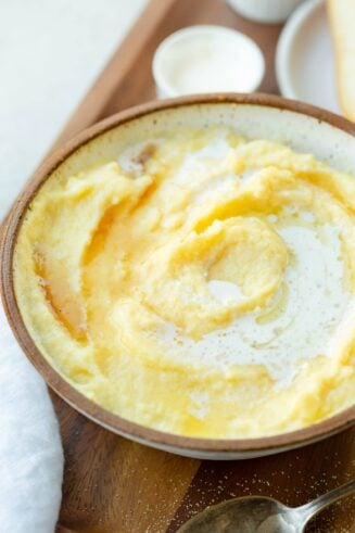a photo of a large bowl full of creamy cornmeal mush that has been drizzled with honey.