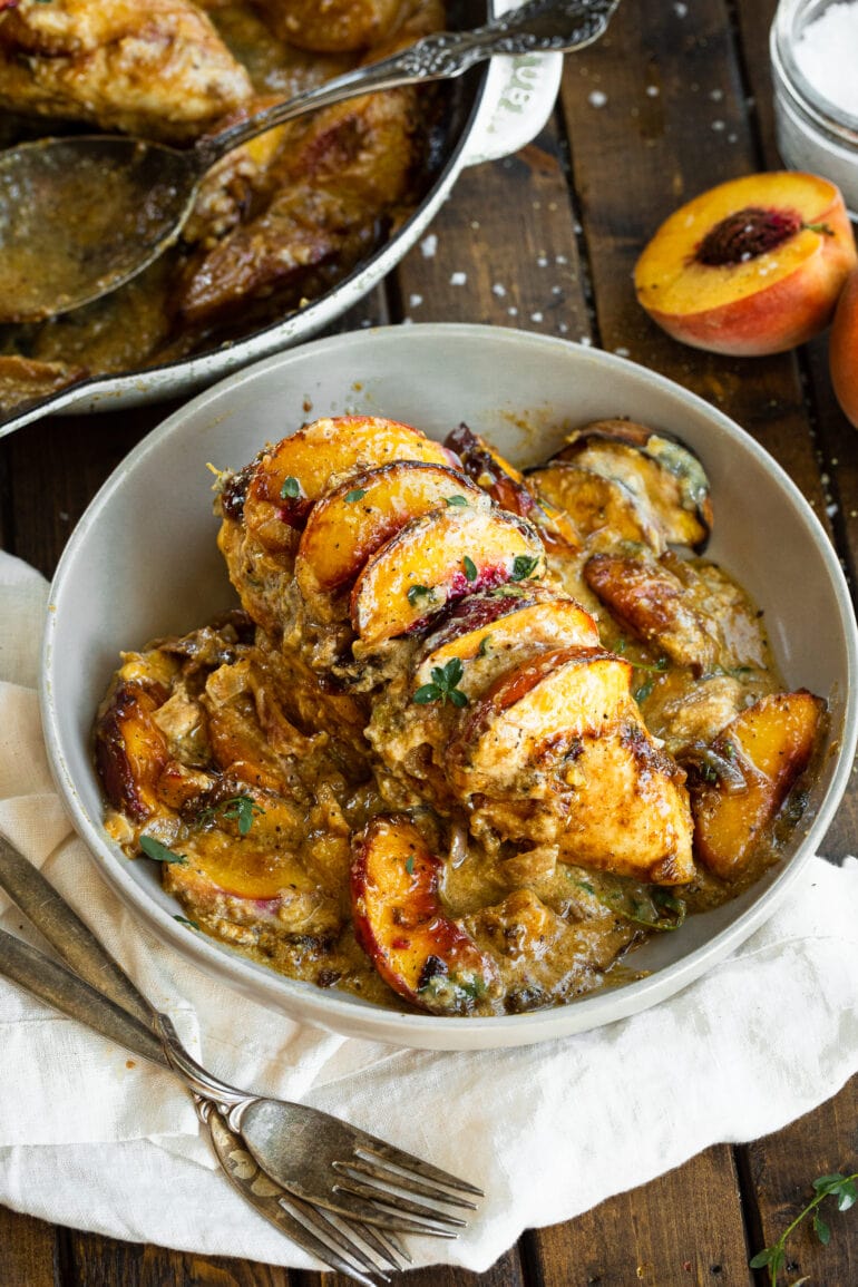 a photo of baked creamy chicken breasts topped with sliced peaches