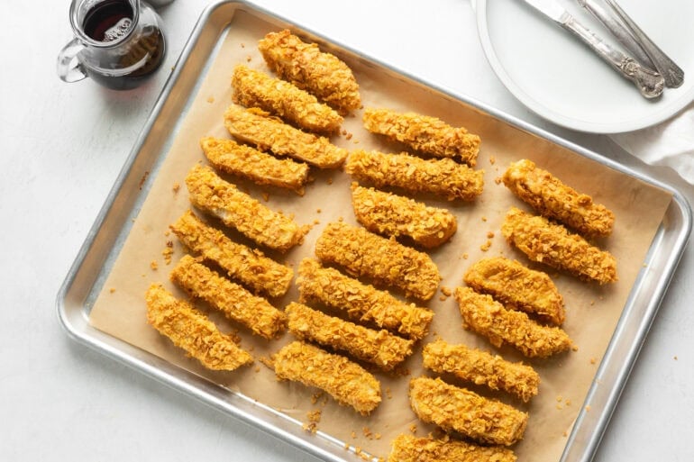 a sheet pan full of crunch french toast sticks ready to bake