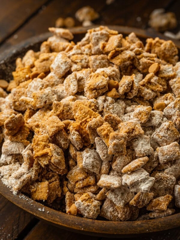 a large wooden bowl of double peanut butter muddy buddies snack mix