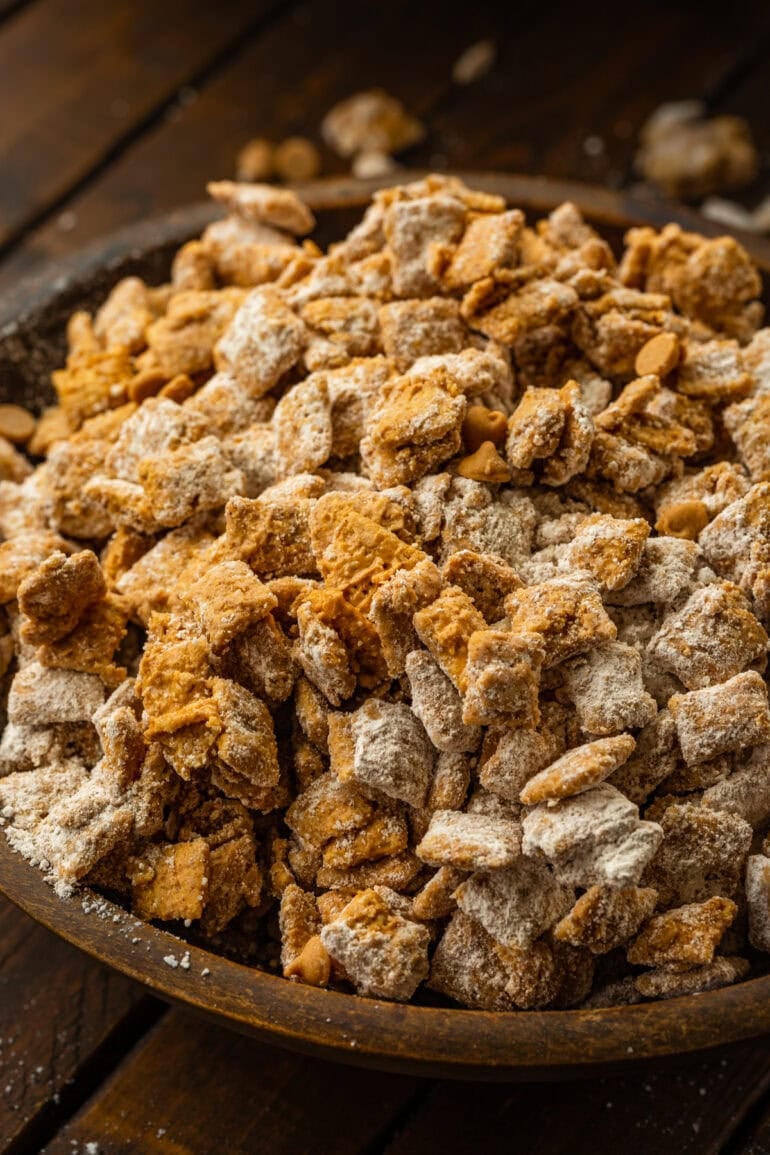 a large wooden bowl of double peanut butter muddy buddies snack mix