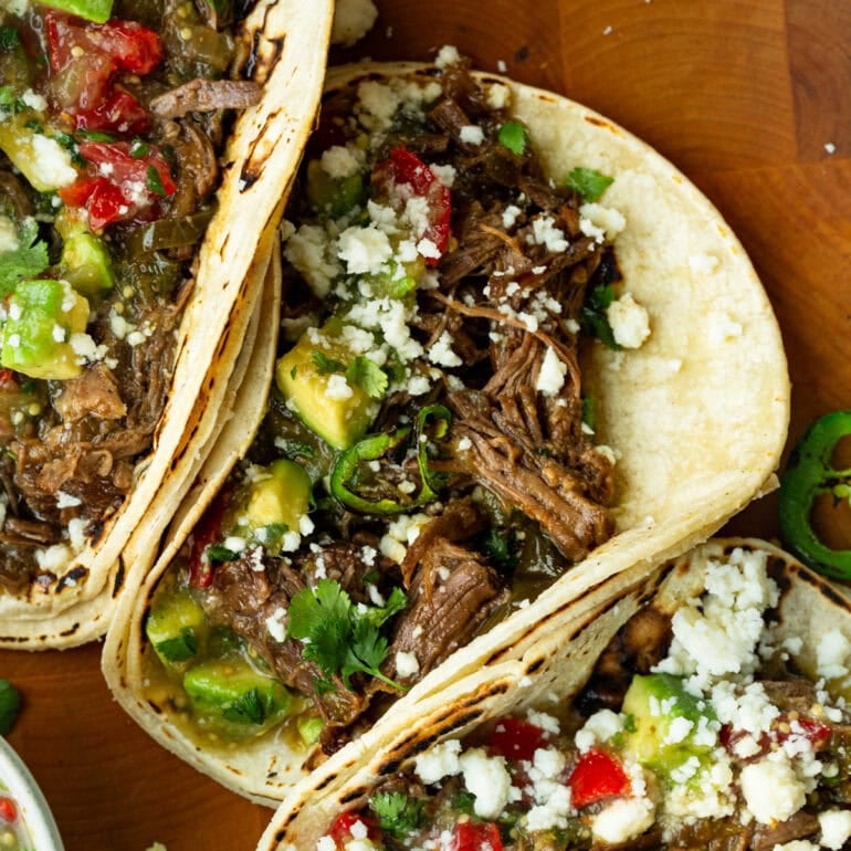 Tender shredded beef with smoky peppers and herbs wrapped in soft tortillas, ready to serve.