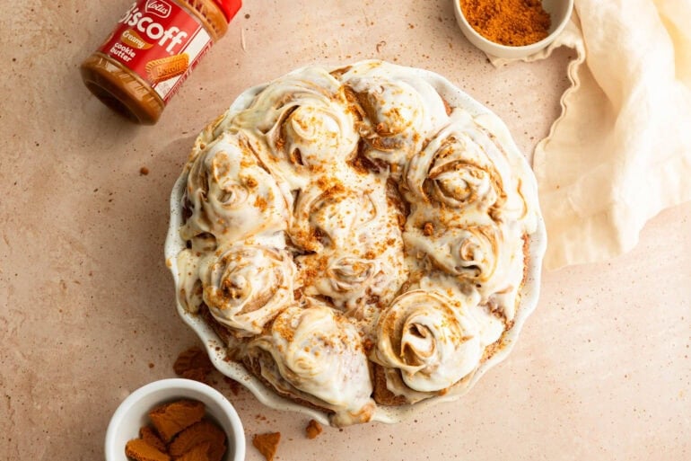 Pan of Biscoff pull apart rolls topped with ribbons of cream cheese frosting and Lotus Biscoff spread