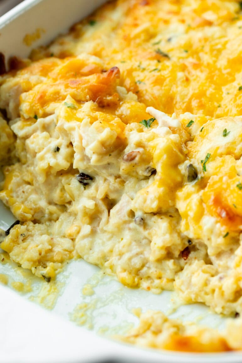 a photo of creamy chicken and rice casserole topped with melted cheese