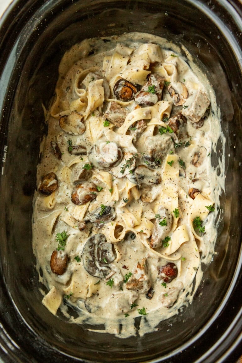 A photo of a slow cooker filled with beef stroganoff