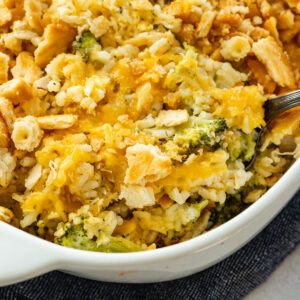 a white casserole dish full of chicken broccoli rice casserole topped with a golden ritz cracker topping