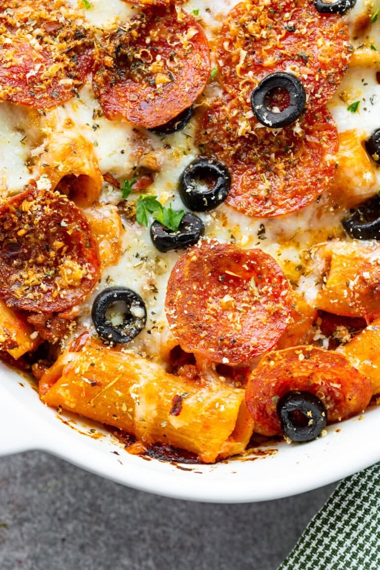 Photo of casserole dish filled with grilled pizza casserole topped with thinly sliced olives and melted cheese cheese