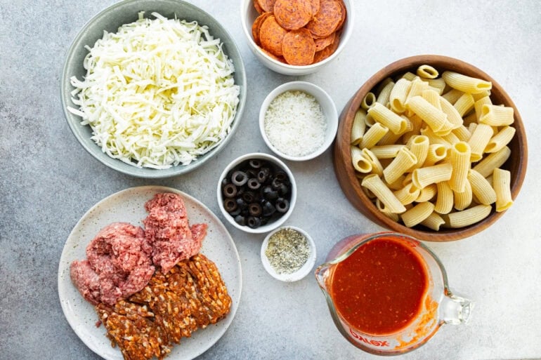 Photo of all the ingredients of pizza pasta casserole in separate small bowls