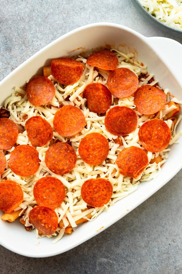 A picture of a pizza casserole, ready to go to the oven in the oven, grind the mozzerella on top and pepperoni