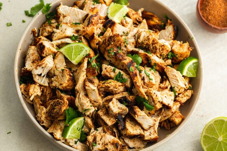 A photo of Mexican Grilled Chicken served in a beige bowl and topped with cilantro and lime