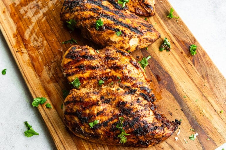 A photo of smoky taco seasoned grilled meat resting on a cutting board with beautiful char marks on both sides.