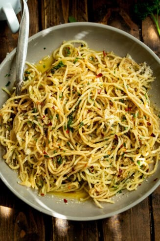 a photo of a large plate full of cooked spaghetti pasta tossed with hot oil and herbs