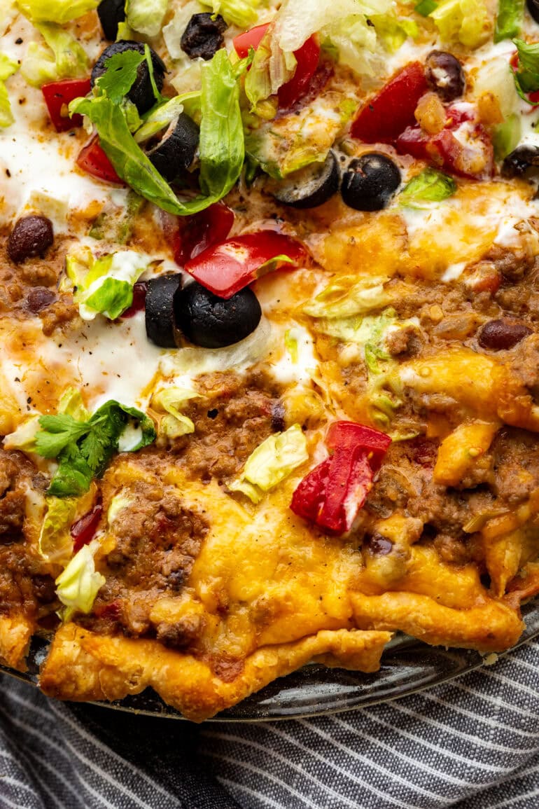 a slice of cheesy taco pie being removed from a full pie plate of it