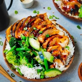 easy teriyaki chicken recipe 2 scaled a photo of a plate of rice covered with teriyaki chicken and steamed broccoli and zucchini.