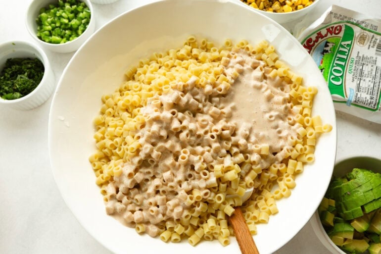 cooked ditalini pasta being stirred with a creamy elote dressing