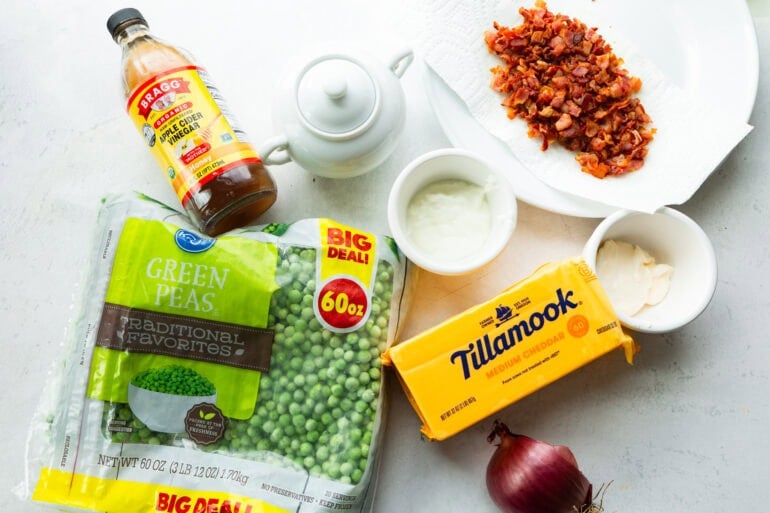 all the ingredients for english pea salad including peas, cheddar cheese, bacon, red onion, etc