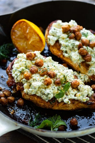 a photo of two roasted chicken breasts topped with creamy feta and crispy seasoned chickpeas