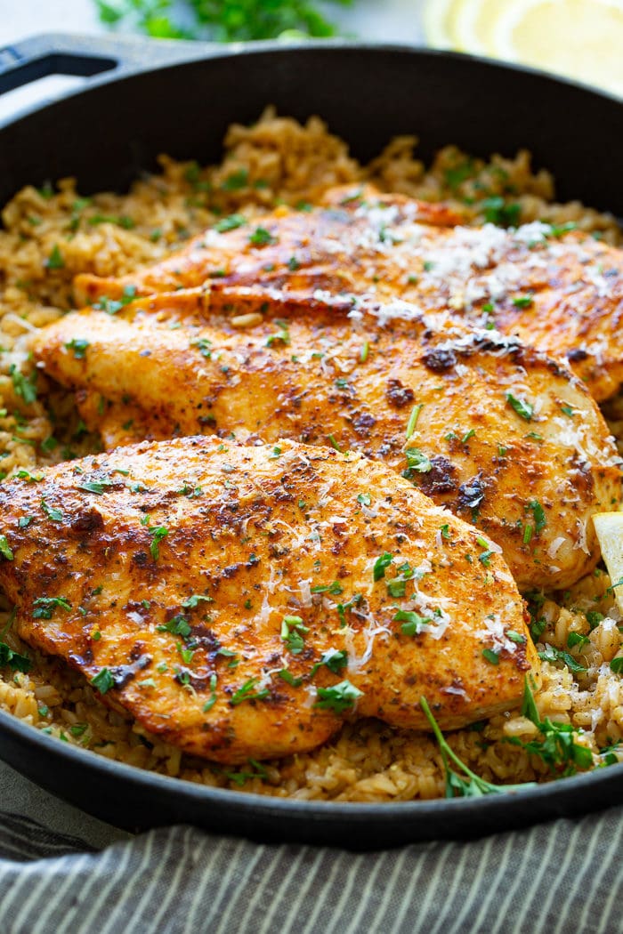 a cast iron pan full of simple garlic butter parmesan chicken with lemon rice