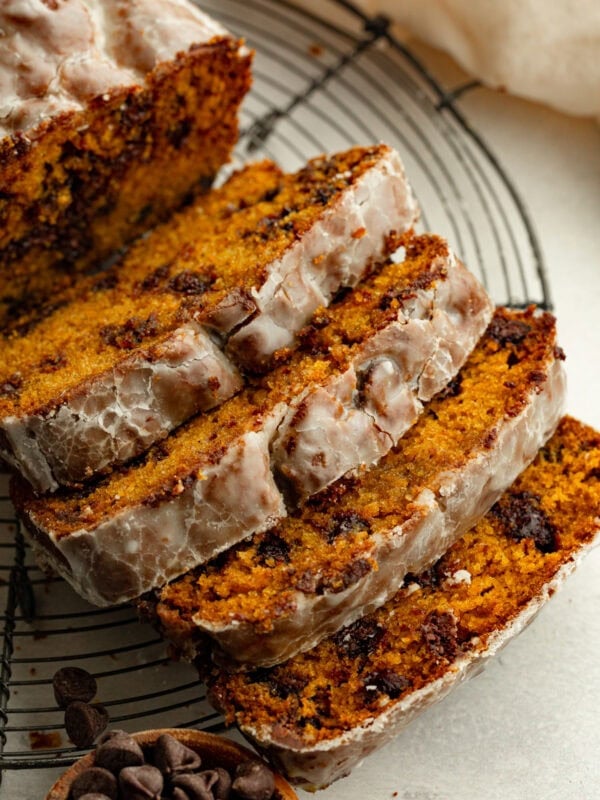 a loaf of glazed pumpkin chocolate chip bread cut into slices