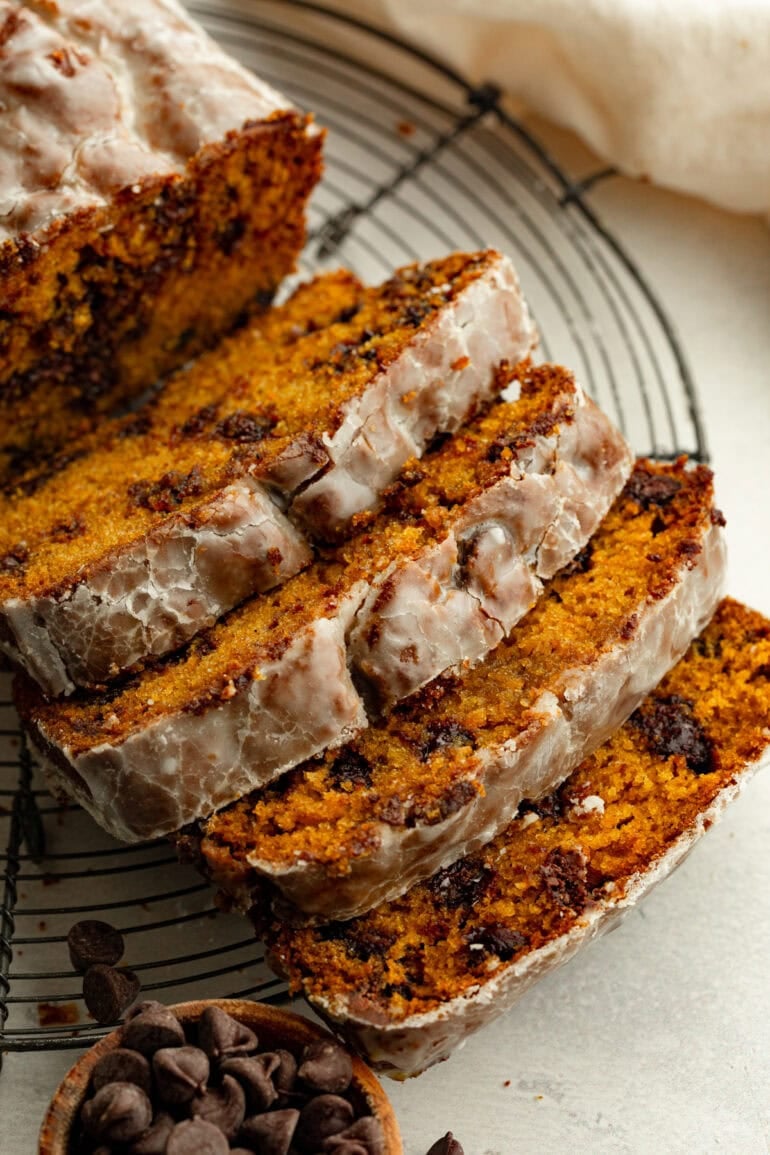 a loaf of glazed pumpkin chocolate chip bread cut into slices
