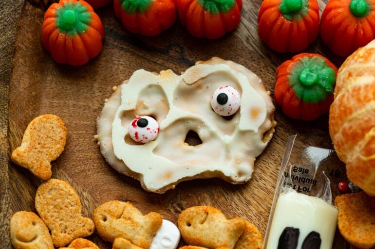 a white chocolate covered pretzel crisp with googly eyes stuck on it