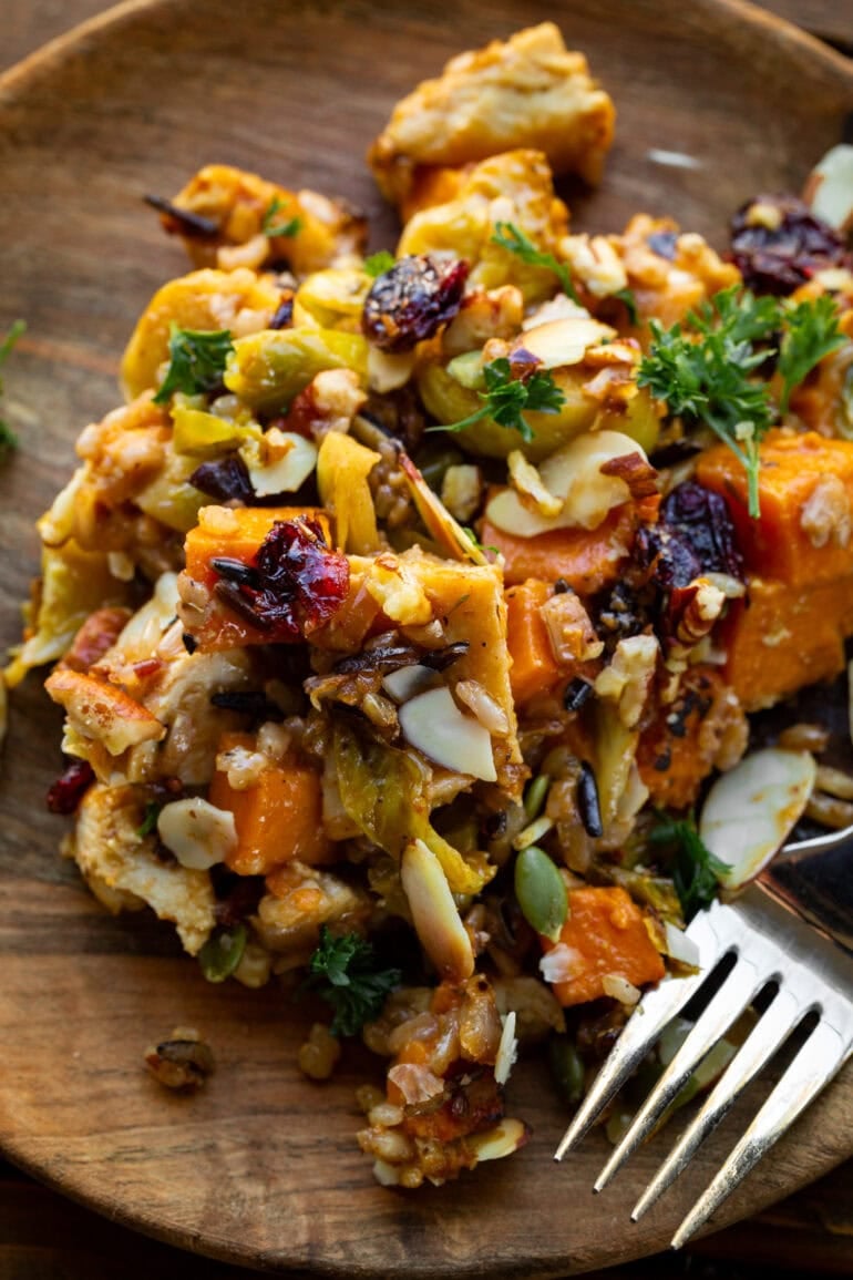 a photo of a wood dinner plate with a serving of harvest chicken casserole with a fork on the side
