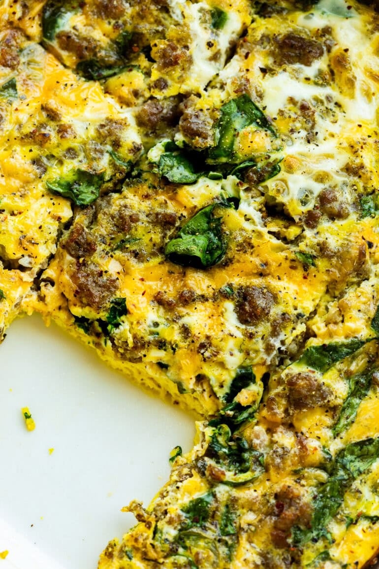 a baked sausage and egg casserole with spinach with a serving removed