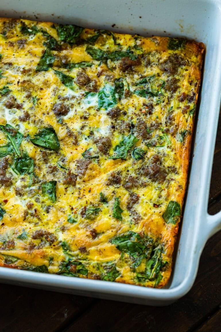 a baking dish full of a baked egg casserole loaded with sausage, spinach and cheese