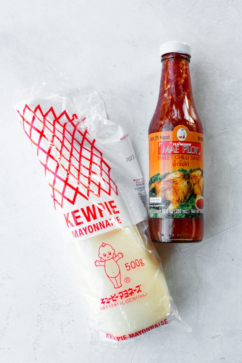 a photo of a kewpie mayonnaise and a bottle of sweet chili sauce.