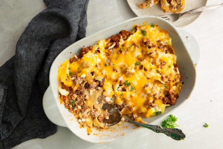 a large serving scooping up a serving of creamy high protein beef noodle casserole