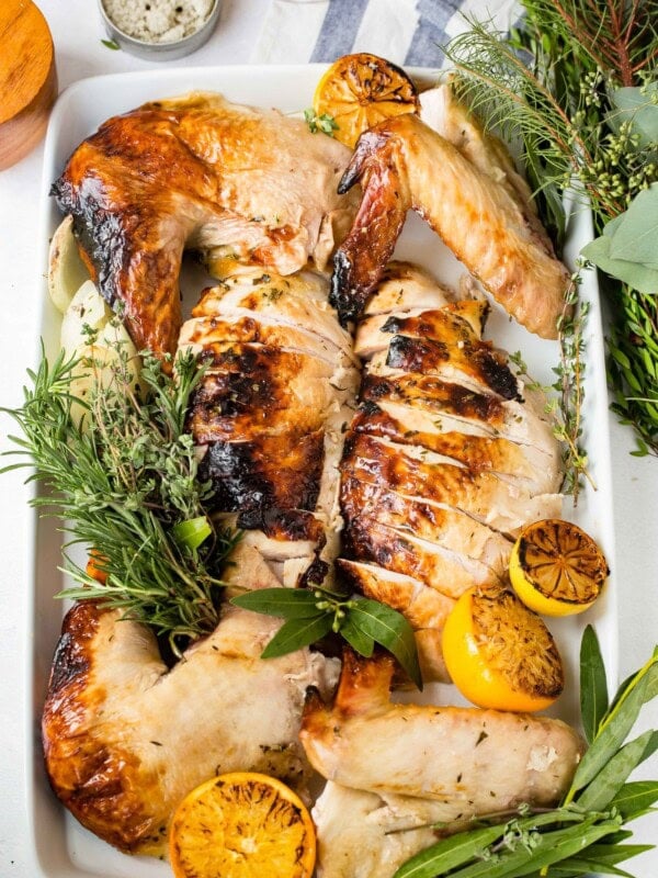 A photo of a carved turkey arranged on a white serving platter.