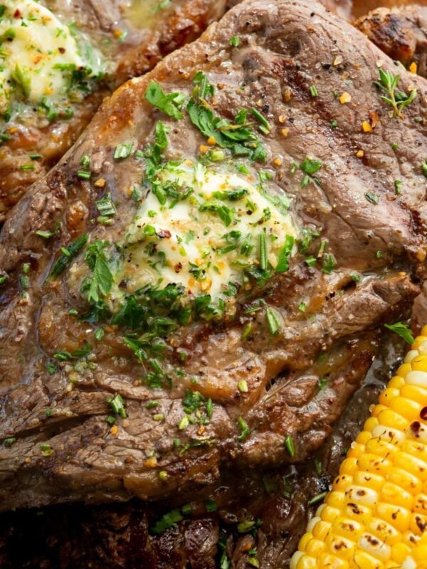 a grilled ribeye steak with a pat of garlic butter on top