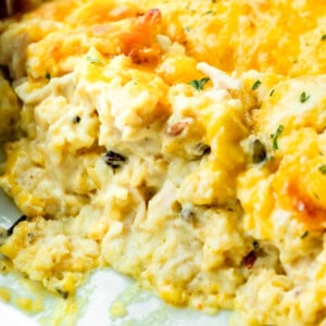 a photo of a chicken and rice casserole in a casserole dish with scoops of the casserole removed