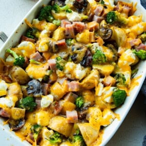 a photo of large white baking dish filled with hearty broccoli potato ham casserole