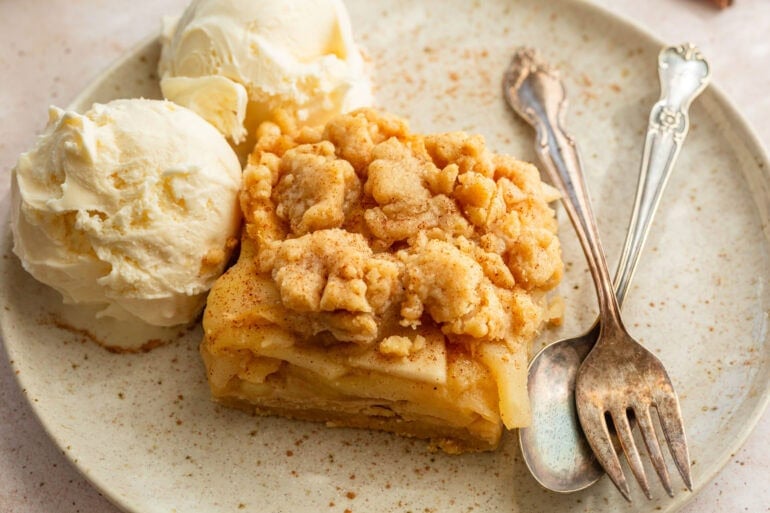 homemade apple pie bars with a scoop of vanilla ice cream on the side