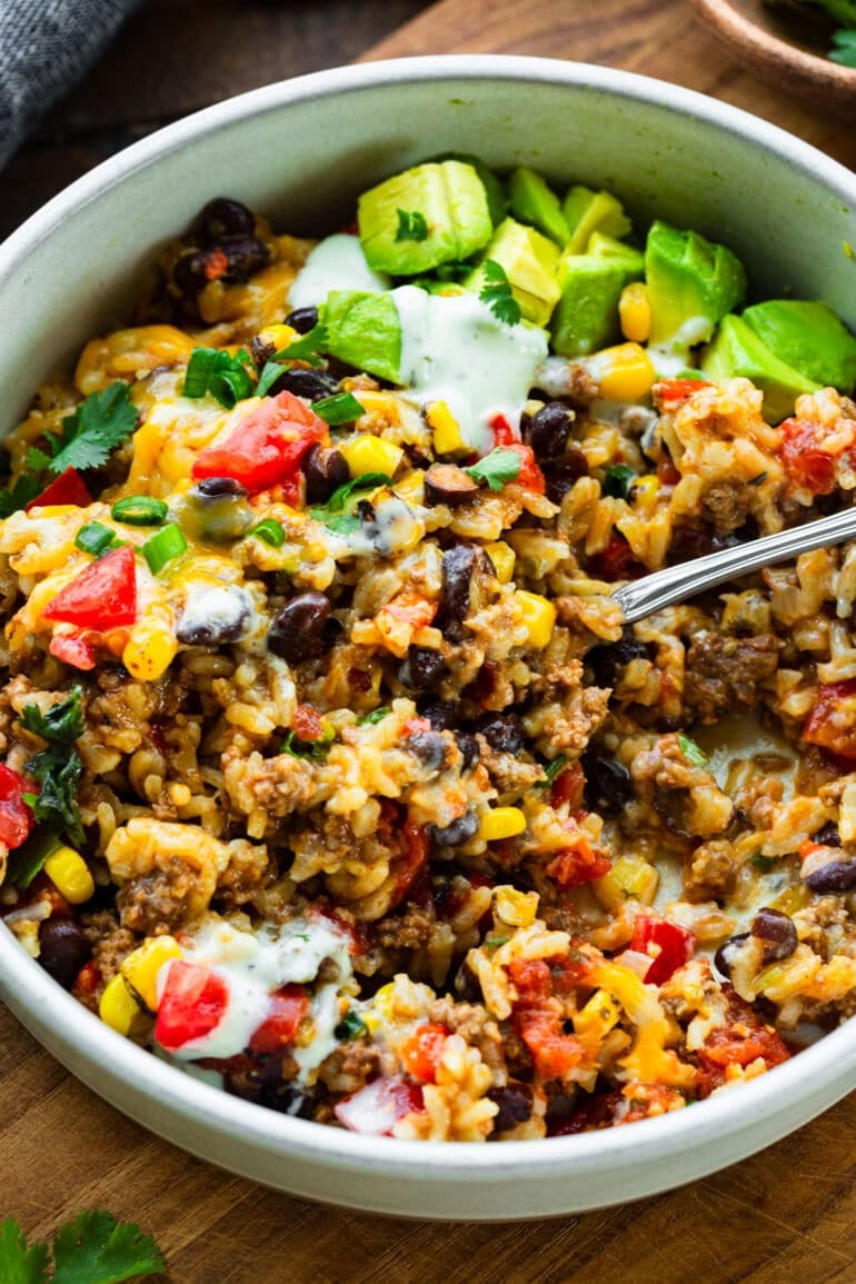 a fork scooping up a bite of ground beef and rice burrito bowl