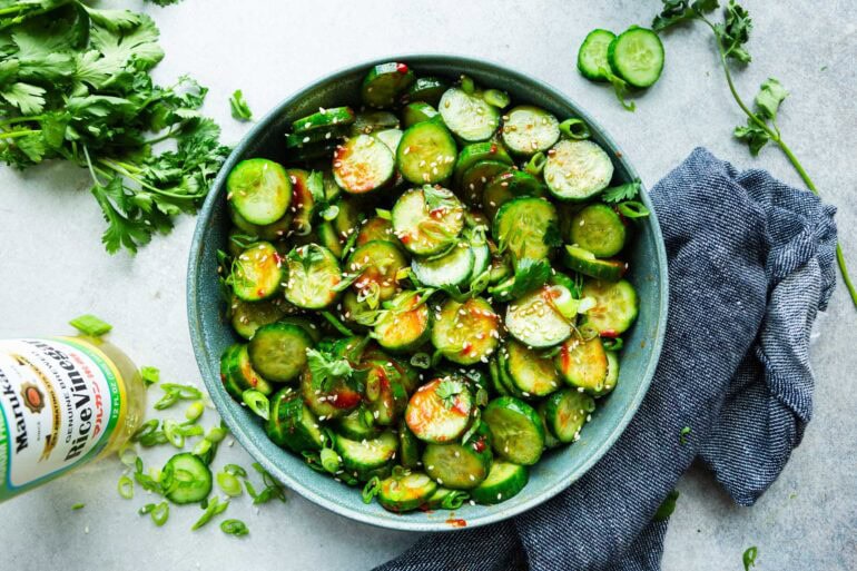 a large blue serving bowl of Korean cucumber salad