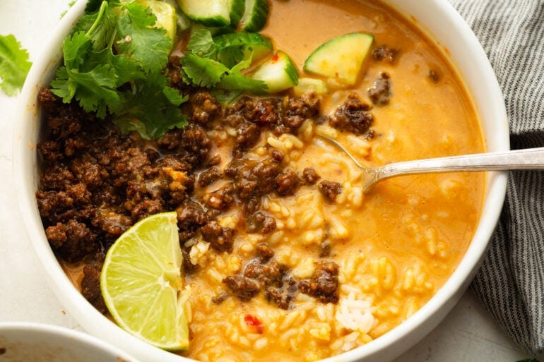 a spoon lifting up a spoonful of korean ground beef broth with rice