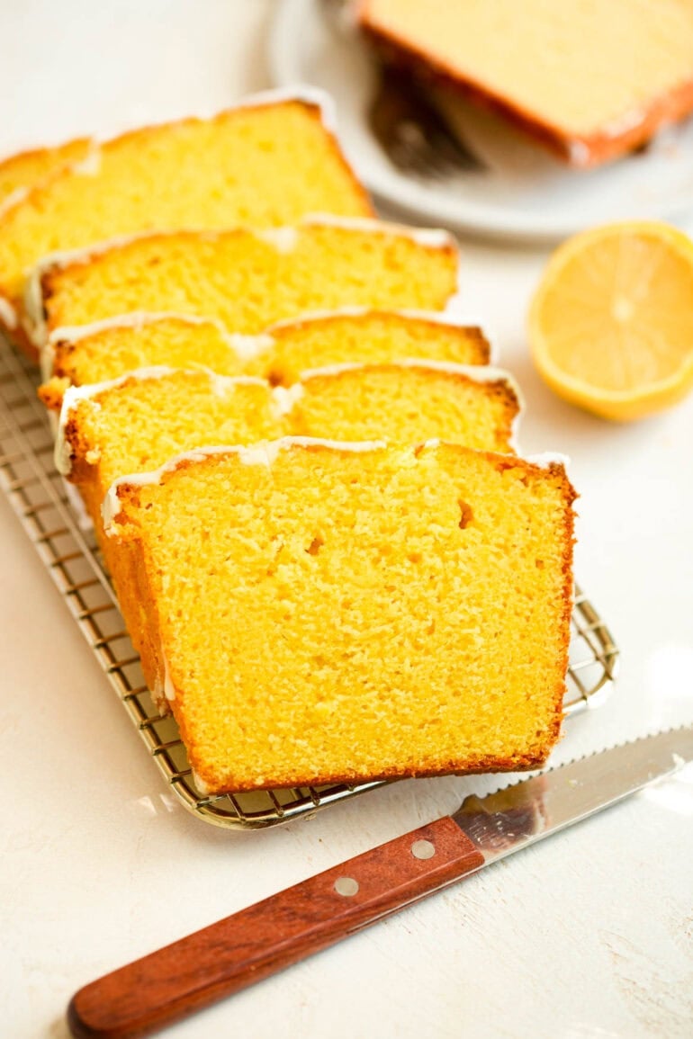 Photo of lemon loaf cake sliced on wire cooling rack