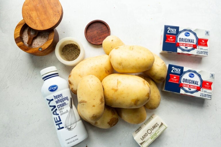 all the ingredients for make ahead mashed potatoes including yukon gold potatoes, cream cheese, butter, cream and salt and pepper