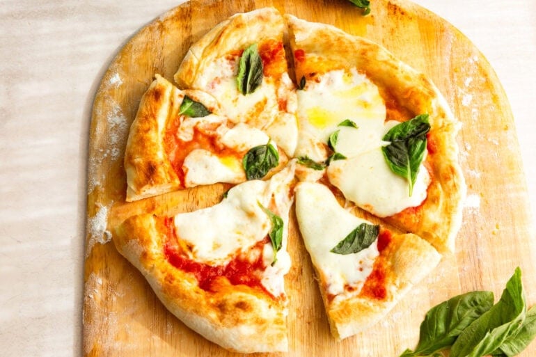 a whole homemade margherita pizza cut into slices