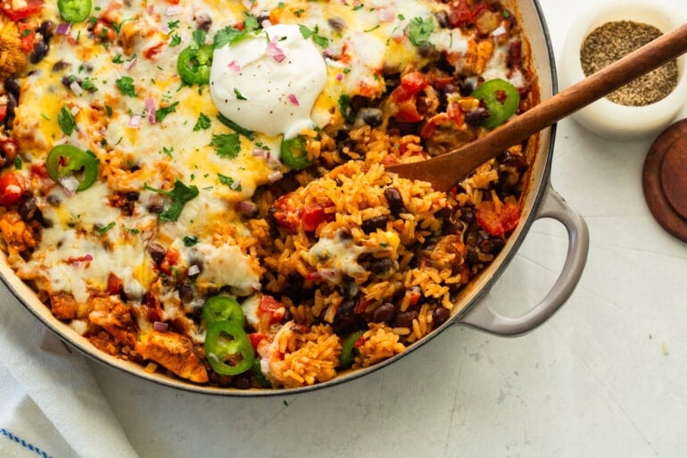 Overhead view of baked chicken taco casserole in an enameled baking dish.