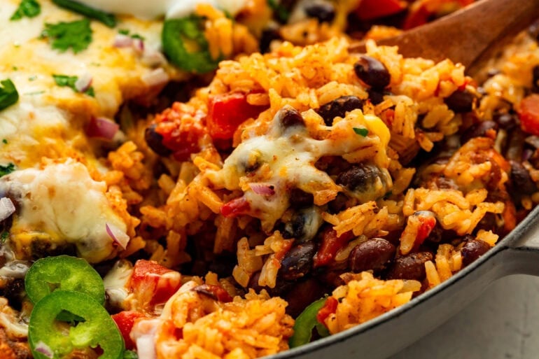 Chicken taco casserole baked until bubbly in an enameled pan, close-up angle