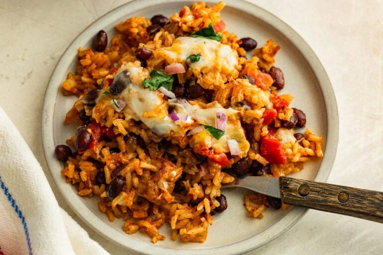 Overhead image of a plate of baked chicken taco casserole on a plate with a fork.
