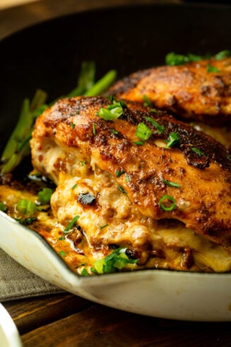 a photo of a stuffed chicken breast that has been baked to golden perfection with gooey cheese spilling out of the chicken